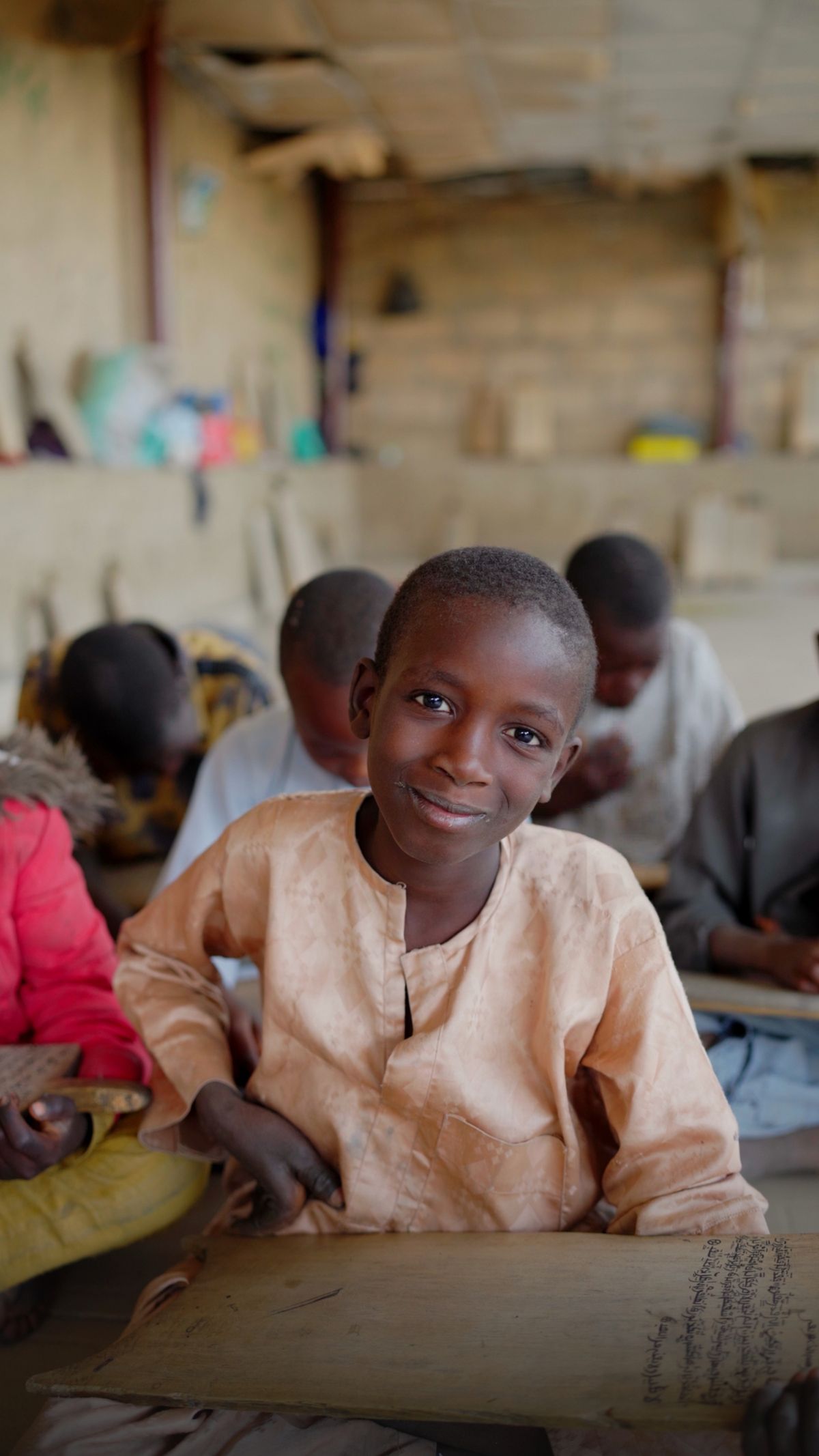 A smiling schoolboy at his desk