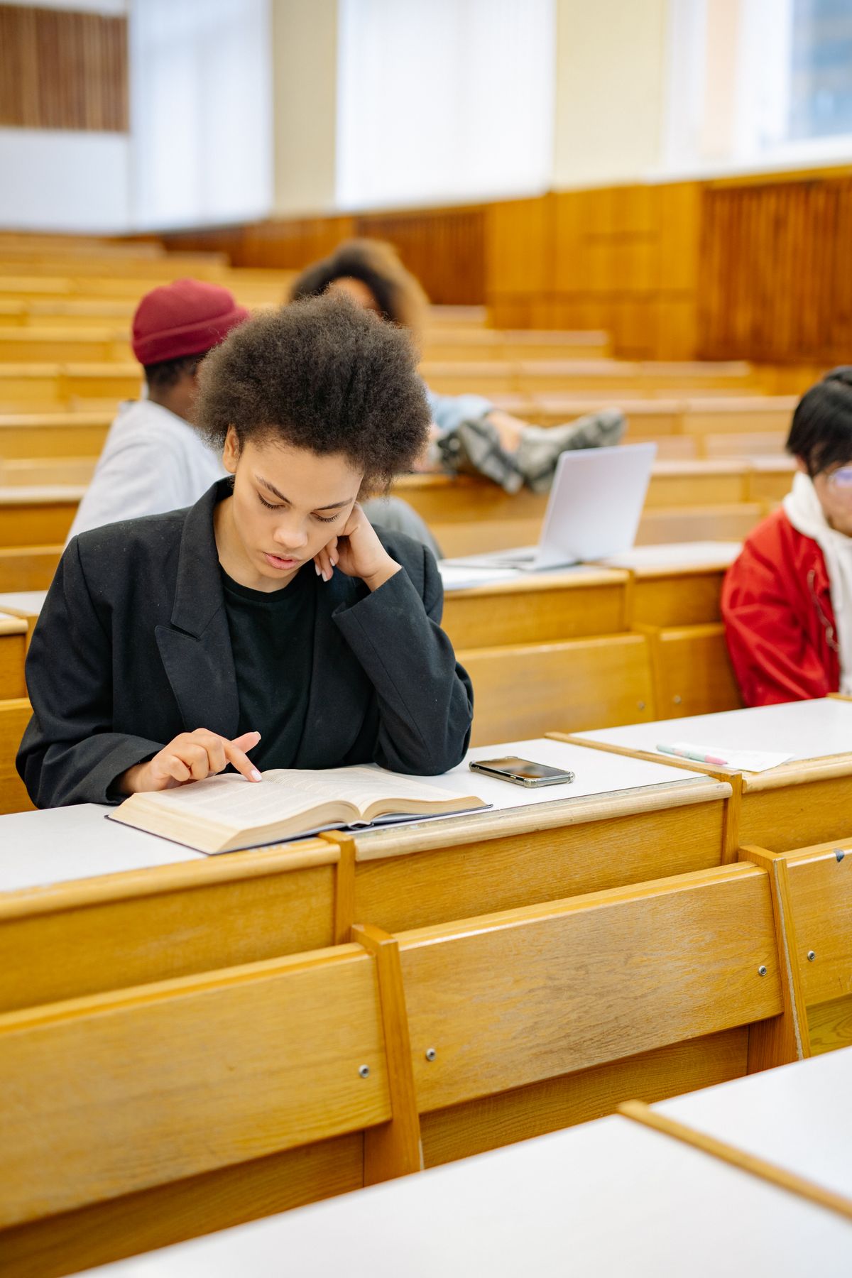 A student reading in a lecture hall