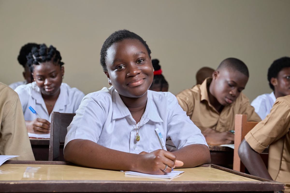 A student smiling at her desk in class